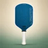Honolulu J2CR Crystal Blue Endurance 16mm Pickleball Paddle - White, front view on a sand and green studio background Honolulu J2CR Crystal Blue Endurance 16mm Pickleball Paddle - White, front view