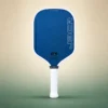 Honolulu J3CR Crystal Blue Endurance 16mm Pickleball Paddle - White, front view on a sand and green studio background Honolulu J3CR Crystal Blue Endurance 16mm Pickleball Paddle - White, front view