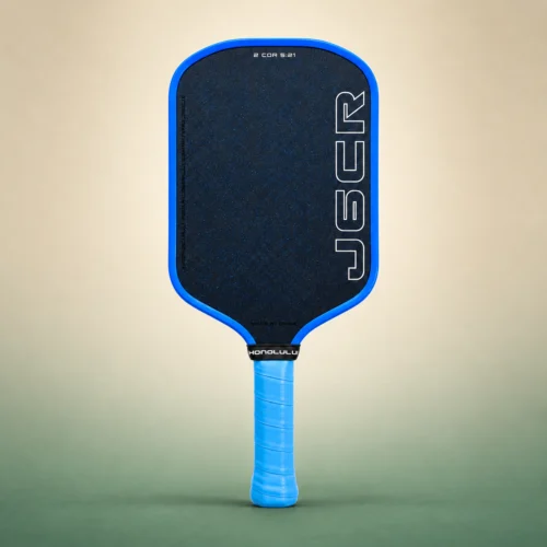 Honolulu J6CR Crystal Blue Endurance 16mm Pickleball Paddle, front view on a sand and green studio background Honolulu J6CR Crystal Blue Endurance 16mm Pickleball Paddle, front view