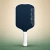 Honolulu J6CR Crystal Blue Endurance 16mm Pickleball Paddle - White, front view on a sand and green studio background Honolulu J6CR Crystal Blue Endurance 16mm Pickleball Paddle - White, front view