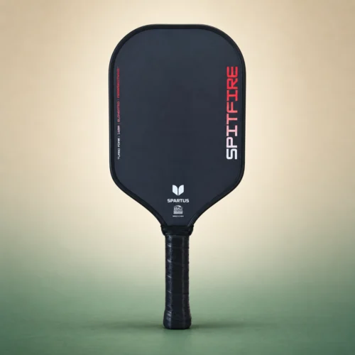 Spartus Spitfire Elongated 16mm Pickleball Paddle, front view on a sand and green studio background Spartus Spitfire Elongated 16mm Pickleball Paddle, front view