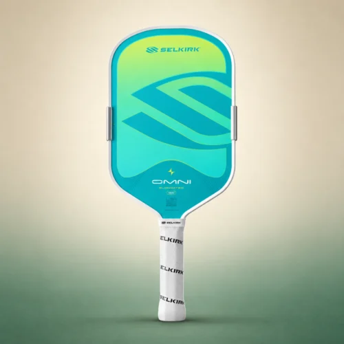 Selkirk OMNI Elongated paddle in Calypso, front view on a sand and green studio background Selkirk OMNI Elongated paddle in Calypso, front view